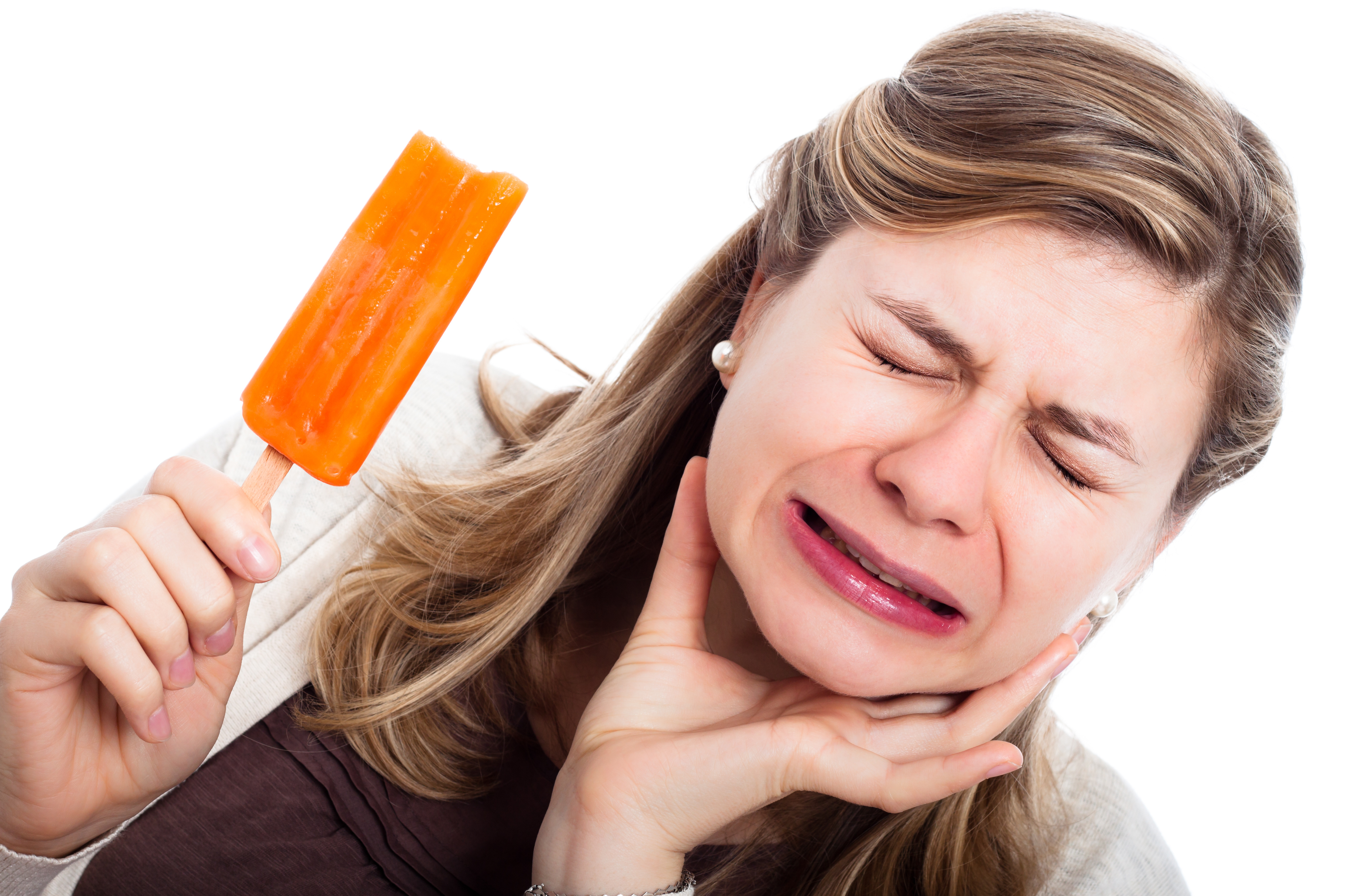 Woman with hypersensitive teeth eating ice lolly